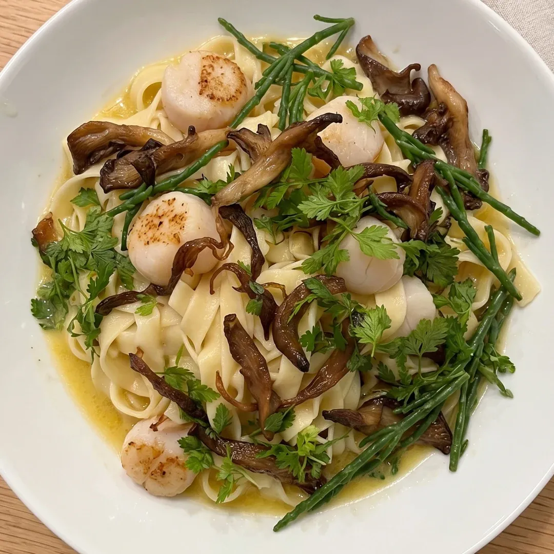 Creamy pasta with seared scallops, sautéed mushrooms, asparagus, and fresh parsley.